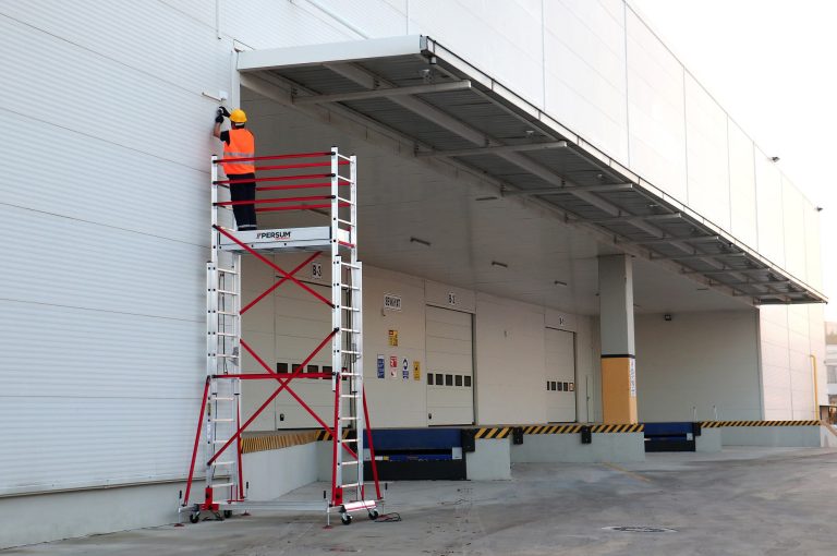 Trabajador en un andamio teletower reparando unas cámaras de seguridad