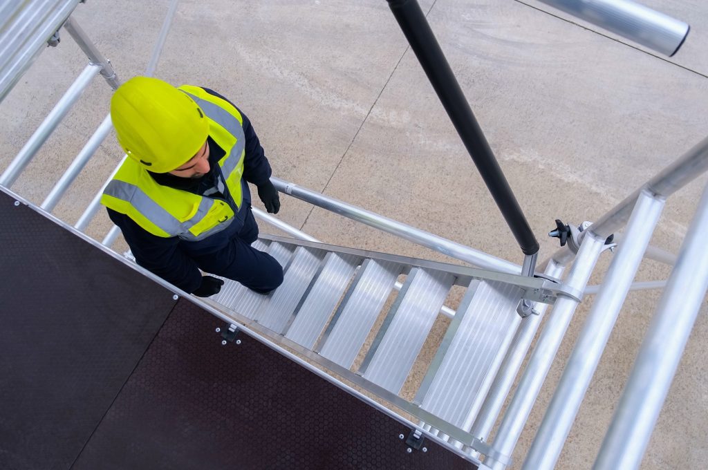 Operario subiendo las escaleras del andamio altezza top le