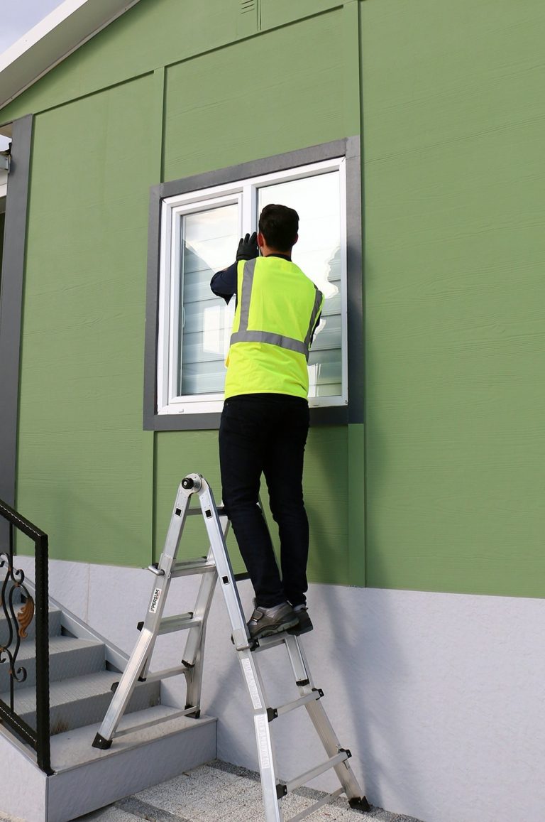 Trabajador montando una ventana sobre la escalera Aquiles