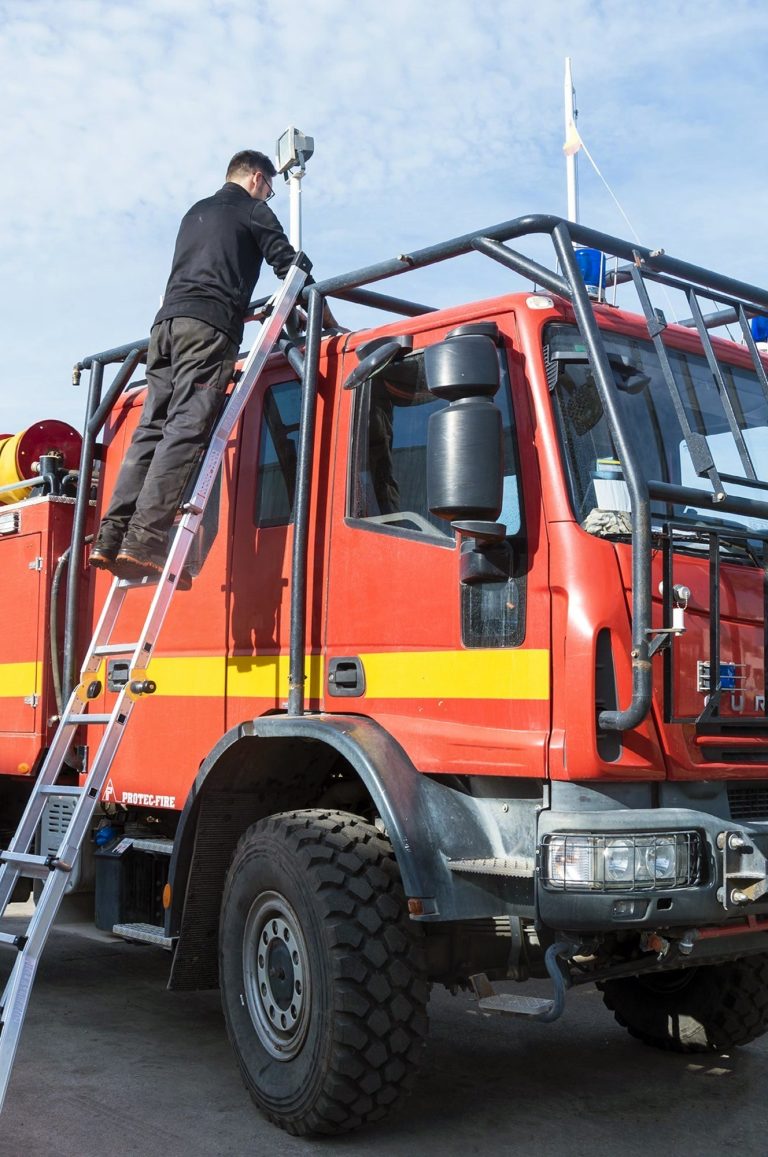 Bombero accediendo a la parte superior de un camión subido a la escalera Aquiles