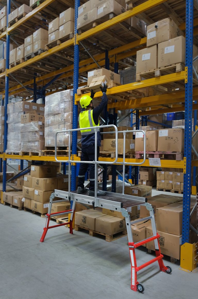 Trabajador en la plataforma industrial Dual Teles organizando un almacén