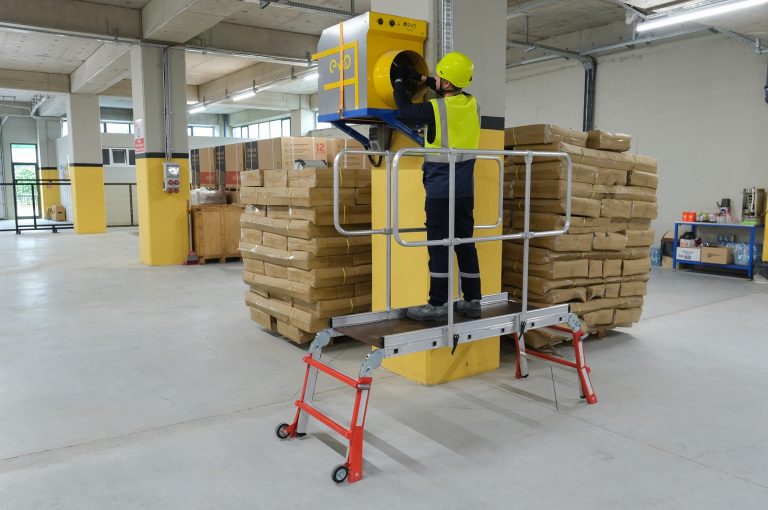 Operario sobre plataforma industrial Dual Teles reparando un extractor