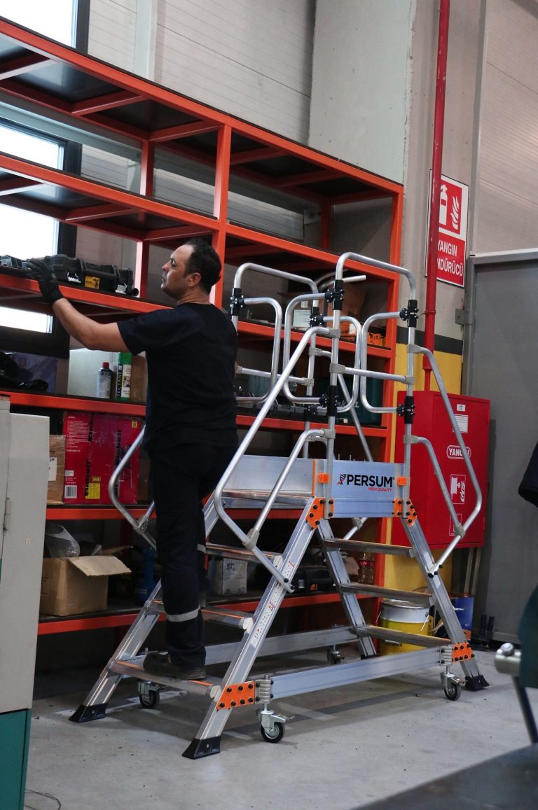 Trabajador sobre plataforma industrial EPC cogiendo material de una estantería