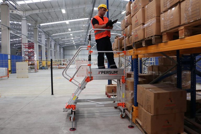 Operario subido a plataforma industrial EPL revisando un pedido
