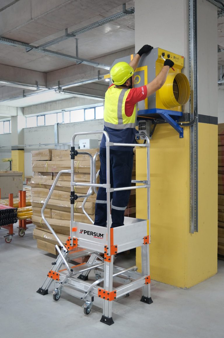 Operario sobre plataforma industrial EPN reparando un extractor