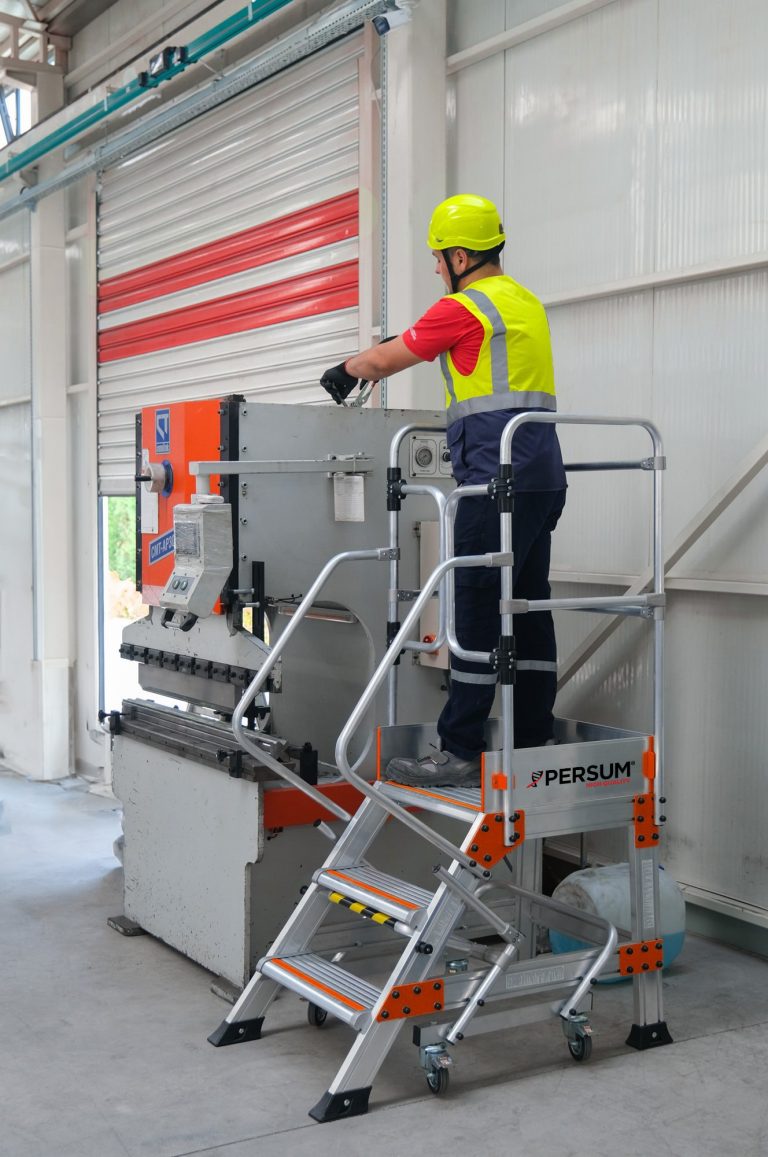 Operario sobre plataforma industrial EPN reparando una máquina