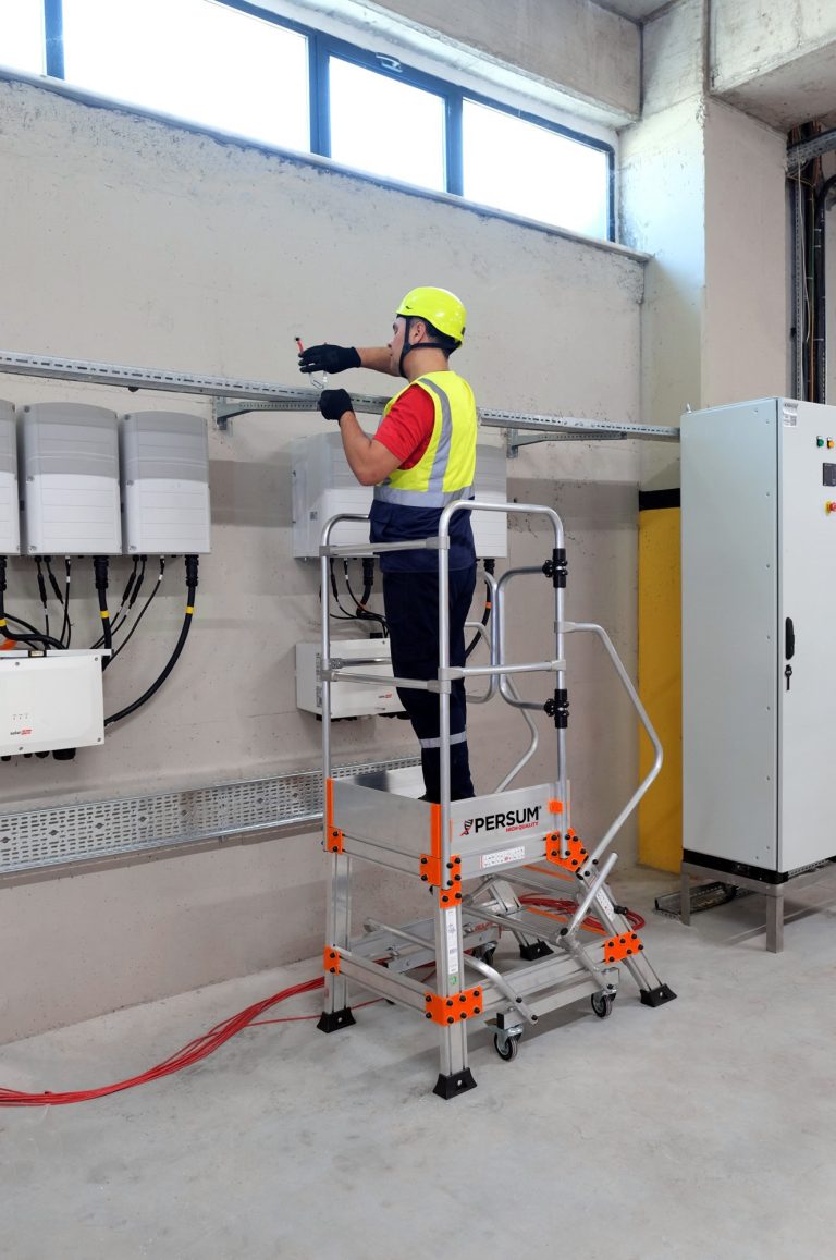 Operario sobre plataforma industrial EPN instalando un cableado