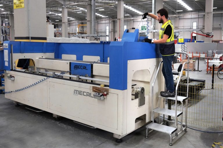 Trabajador sobre taburete kamet limpiando una máquina