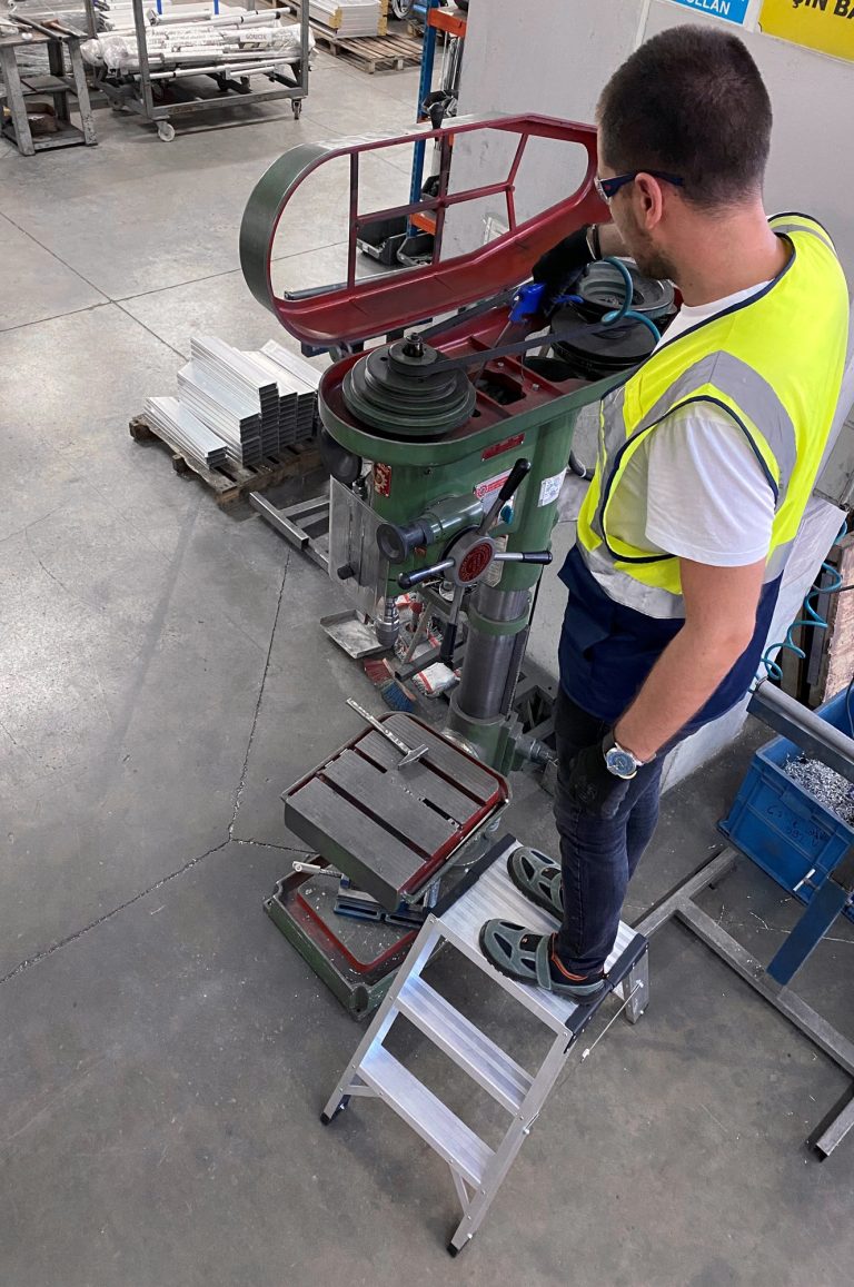 Trabajador limpiando una máquina desde el taburete Teide
