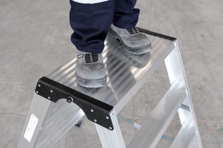 Primer plano de un operario subido en el taburete Teide Plus